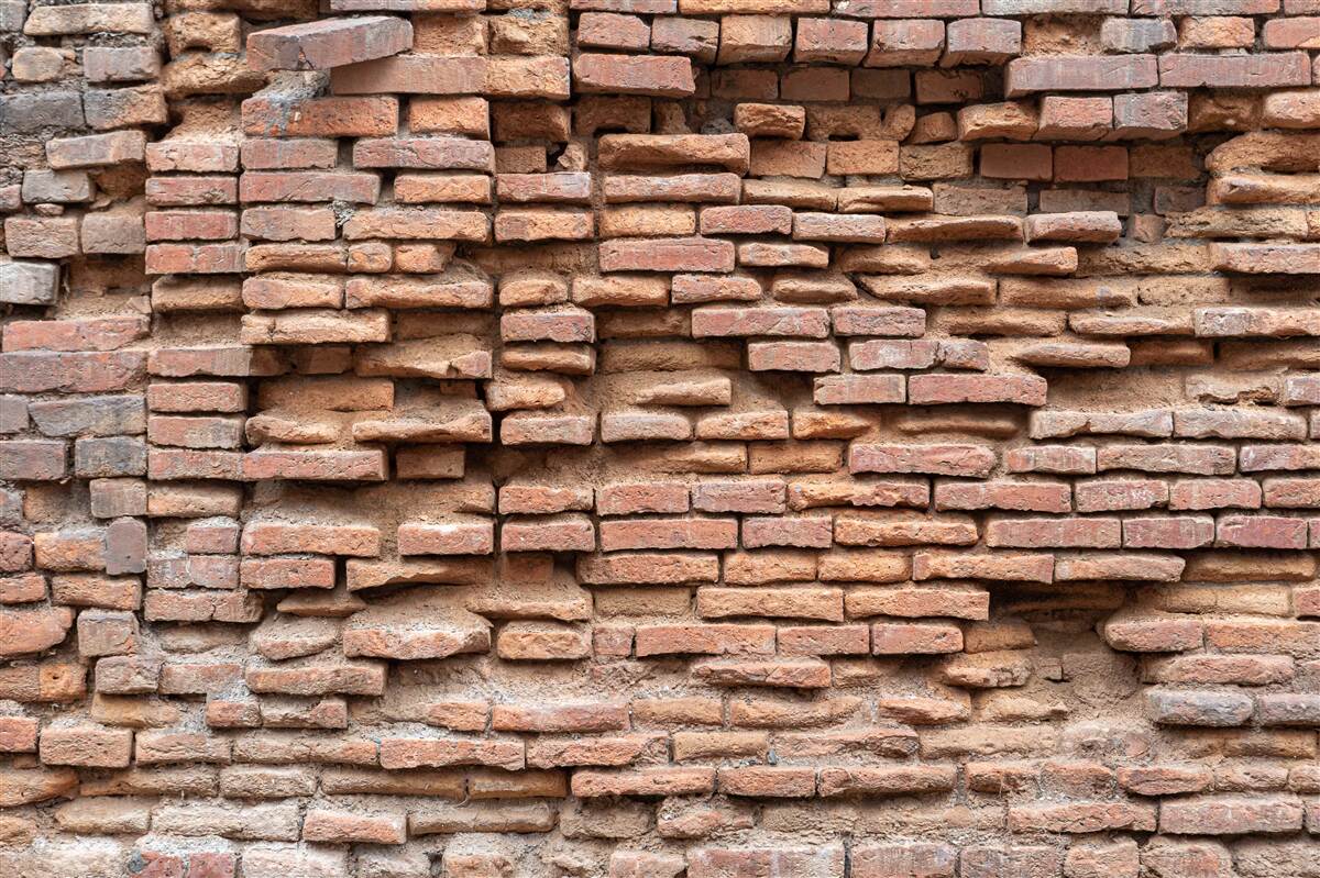 Fotobehang een muur van steen die afbrokkelt