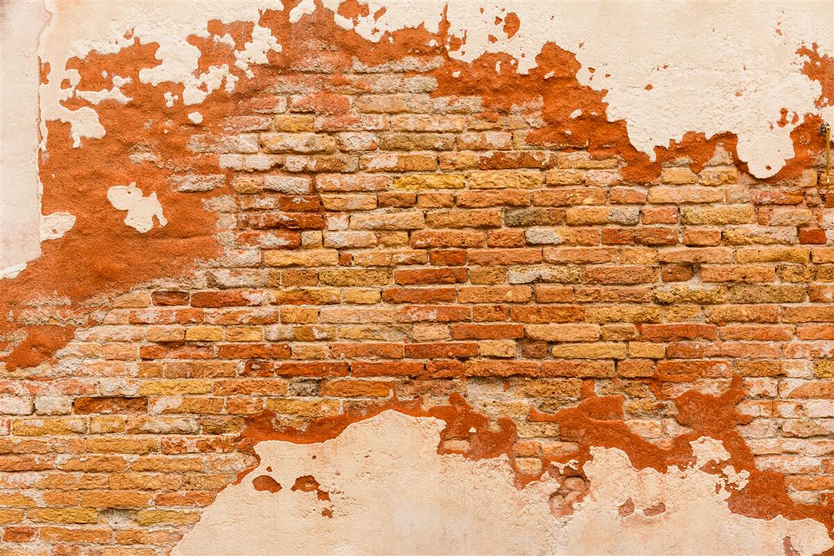 Fotobehang een bakstenen muur die in de loop der tijd is verslechterd