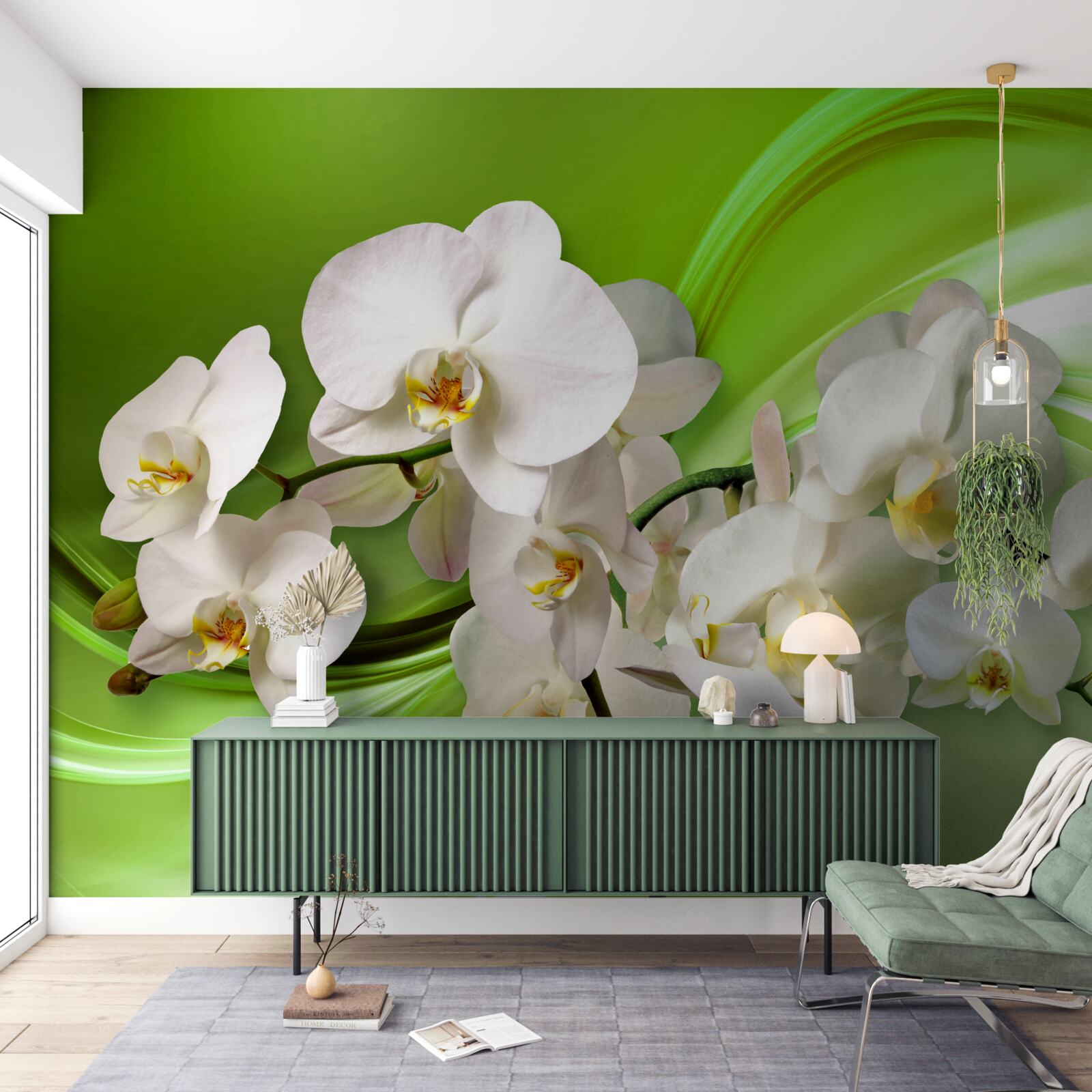 Fotobehang witte orchideeën op een tak tegen een groene achtergrond