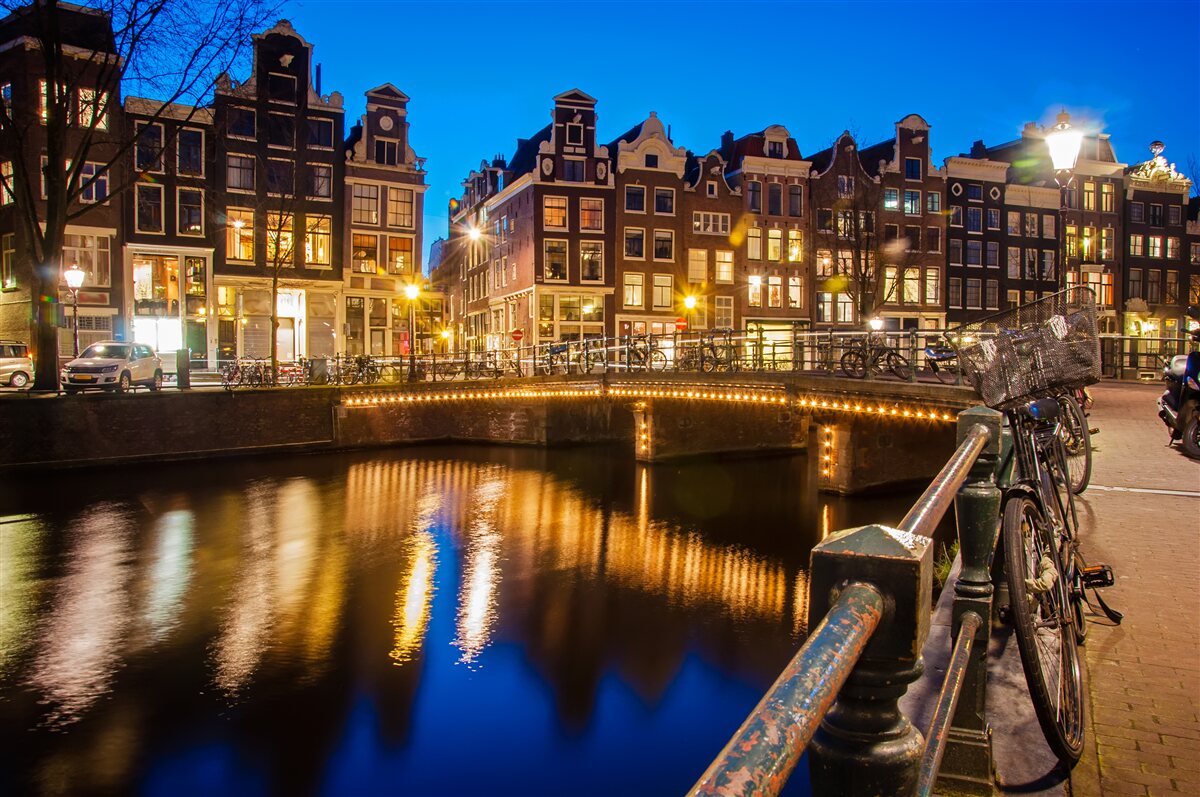 Fotobehang weerspiegeling van amsterdam in het water bij nacht