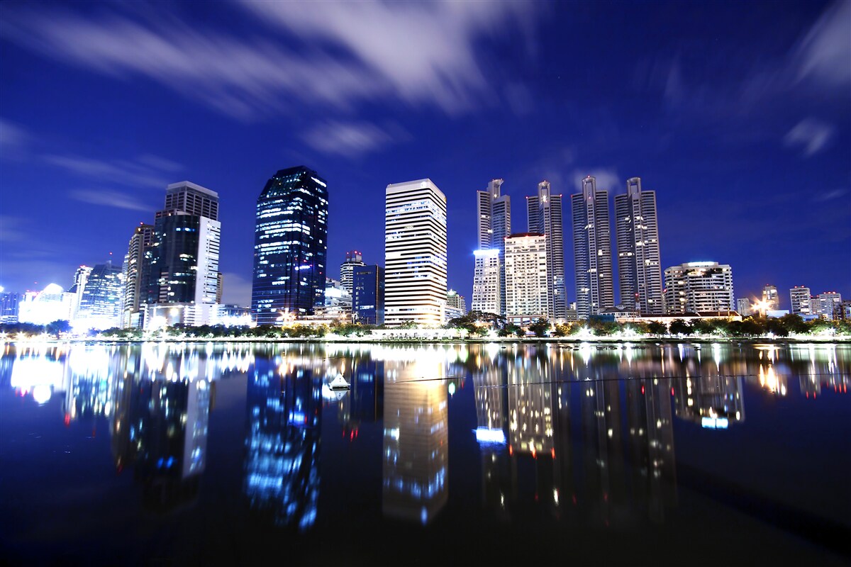 Fotobehang reflectie van wolkenkrabbers in het water bij nacht