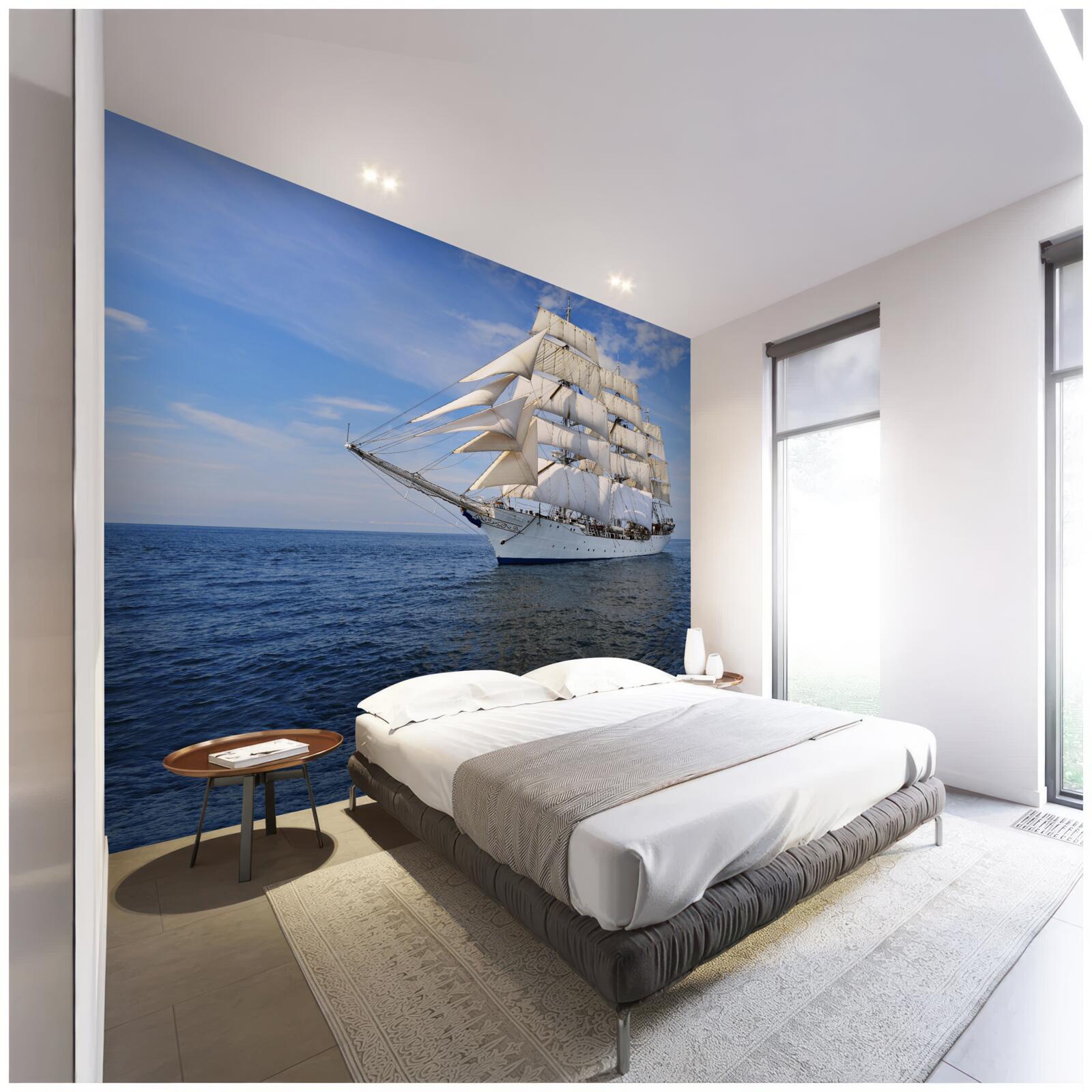 Fotobehang een schip met zeilen op een kalme zee