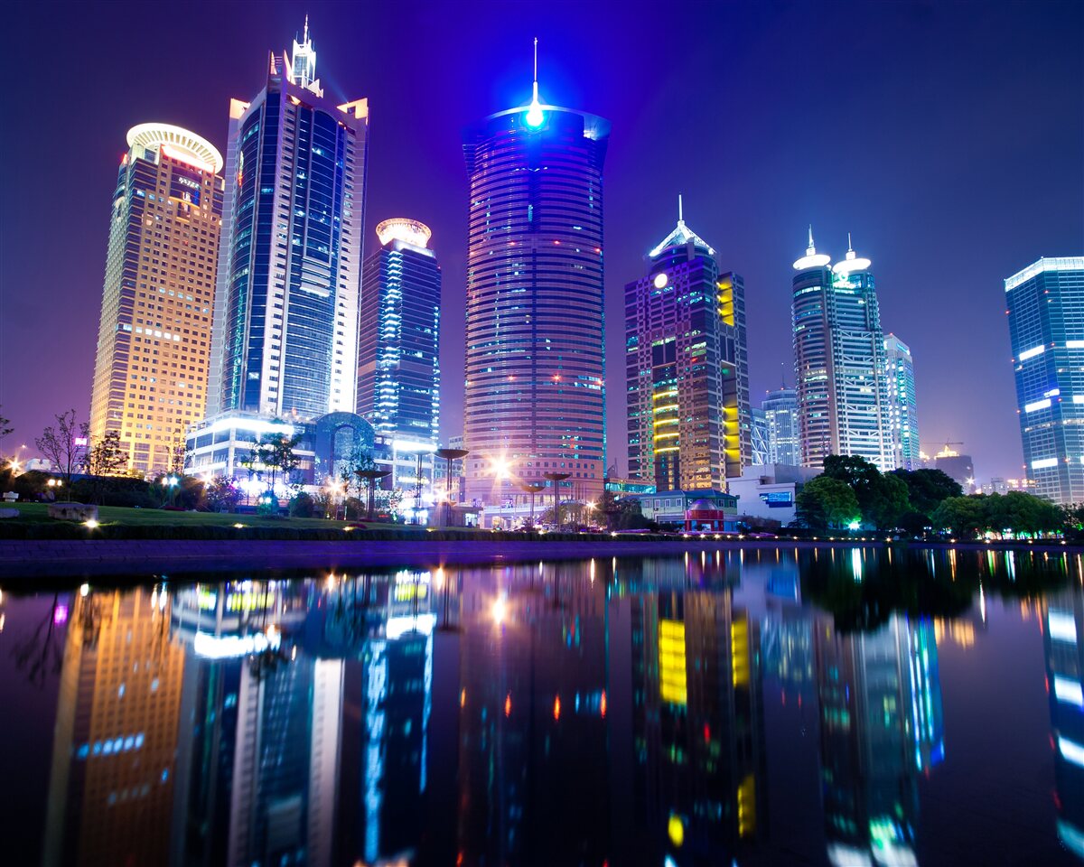 Fotobehang weerspiegelingen van wolkenkrabbers bij nacht