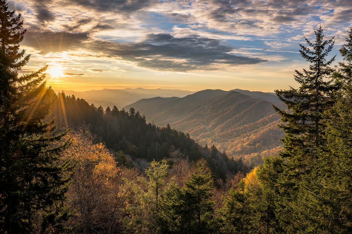 Fotobehang de ondergaande zon over de bergtoppen