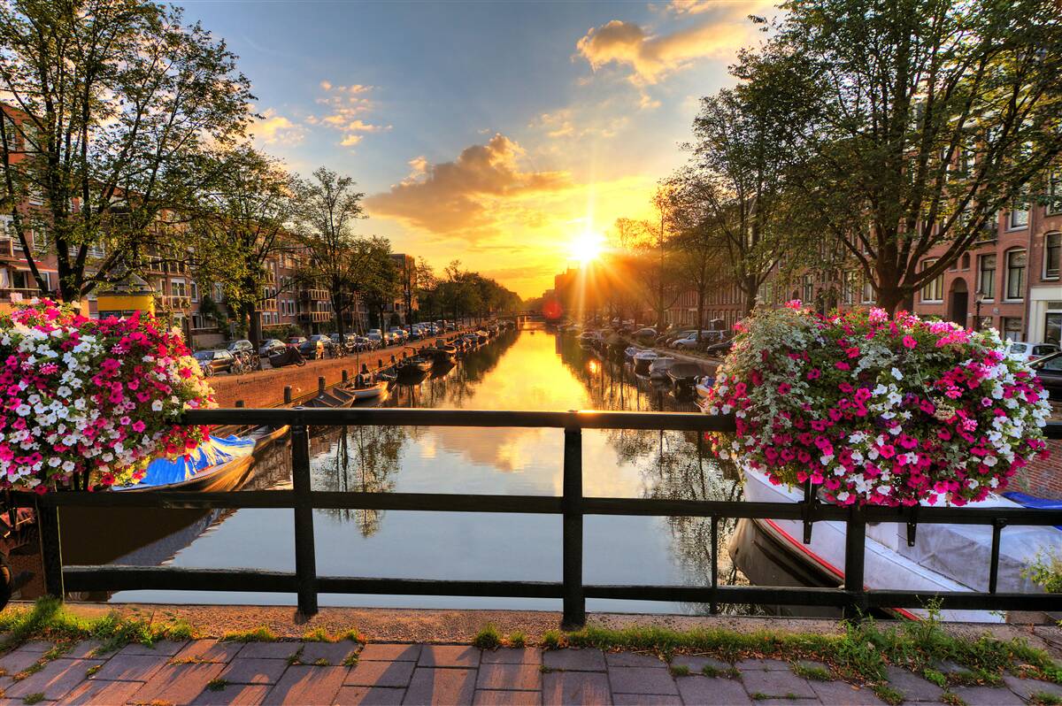Fotobehang kijken naar de zonsondergang vanaf een brug in amsterdam