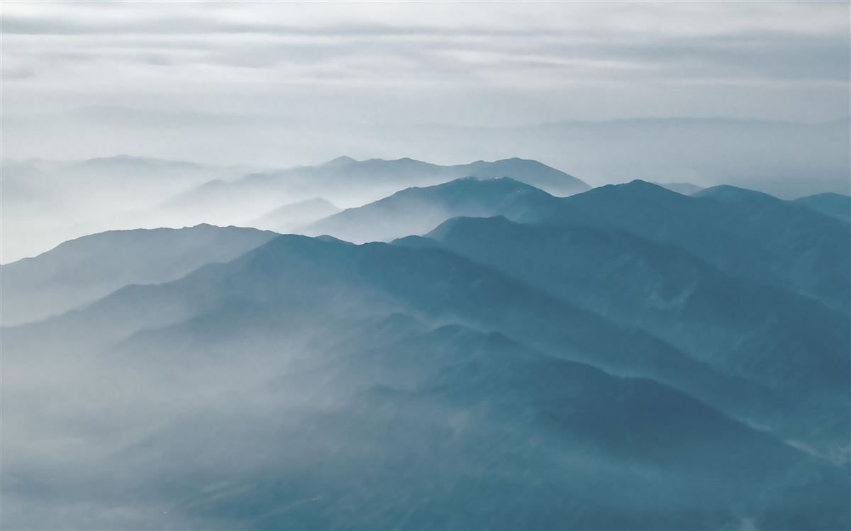 Fotobehang ochtendnevel omhult de bergtoppen