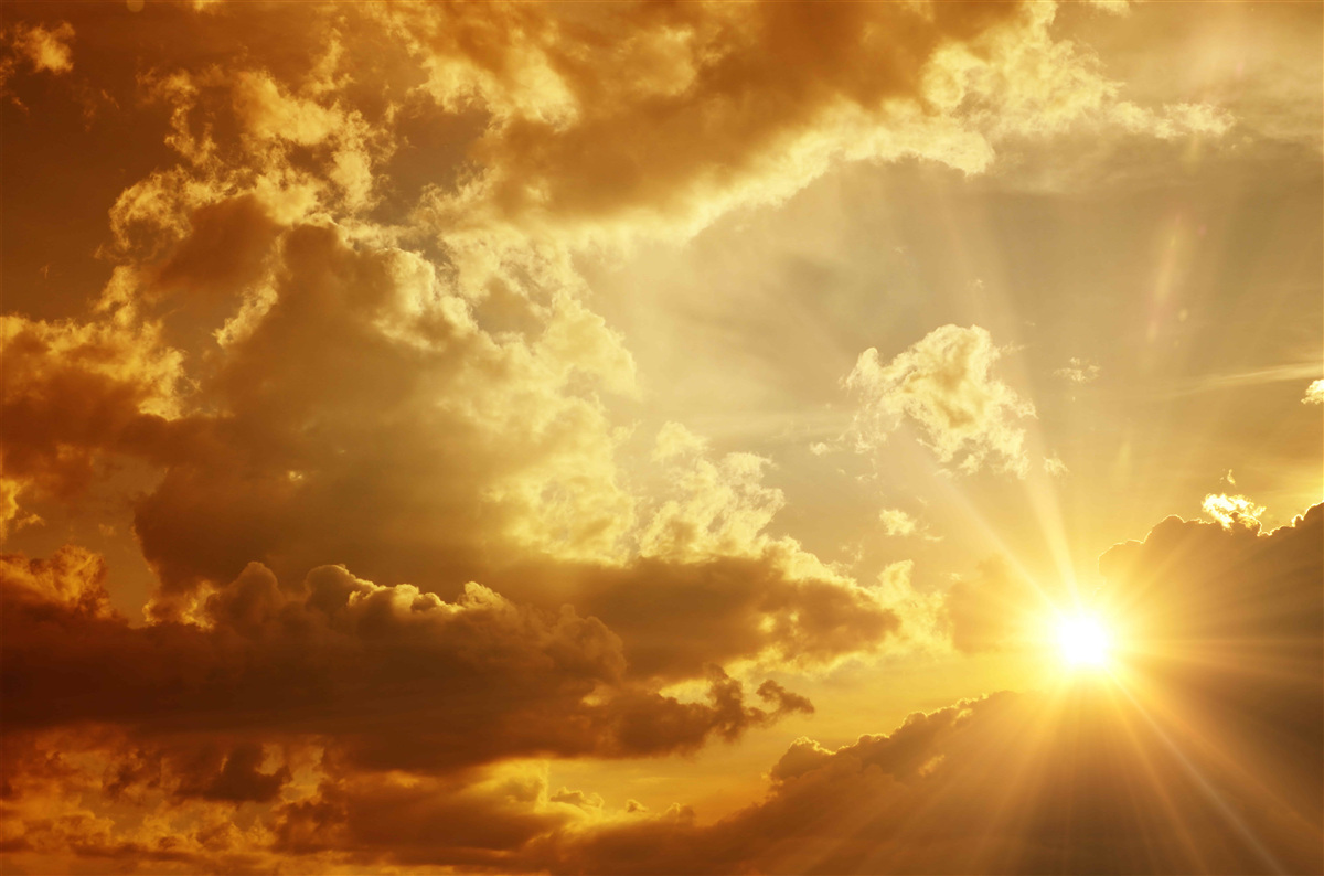 Fotobehang de zonnestralen die bij zonsondergang door de wolken prikken geven warmte af