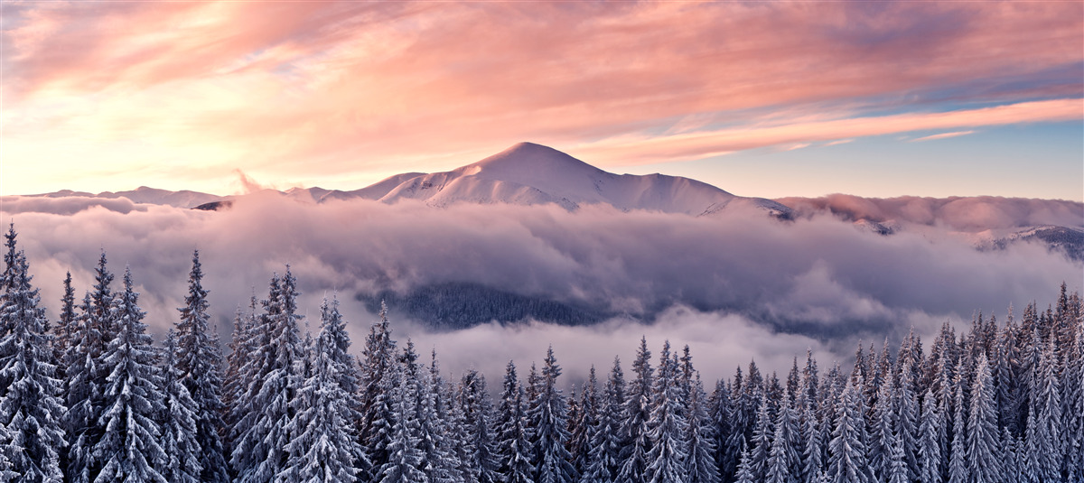 Fotobehang de in mist gehulde zonsondergang in de bergen schildert de ruimte in koele roze tinten