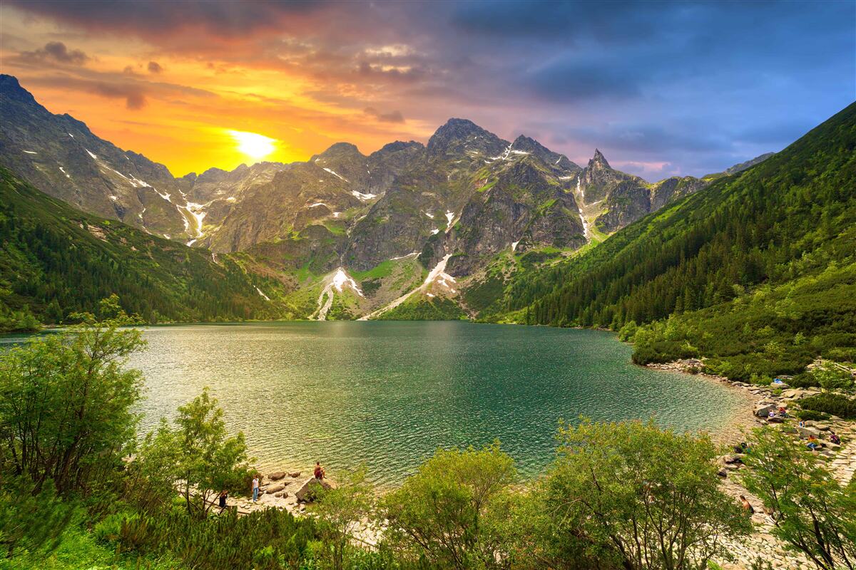 Fotobehang spectaculaire zonsondergang achter de bergketens bij het meer