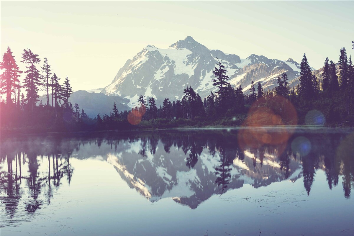 Fotobehang adembenemend uitzicht op bergen en bossen weerspiegeld in kristalhelder water