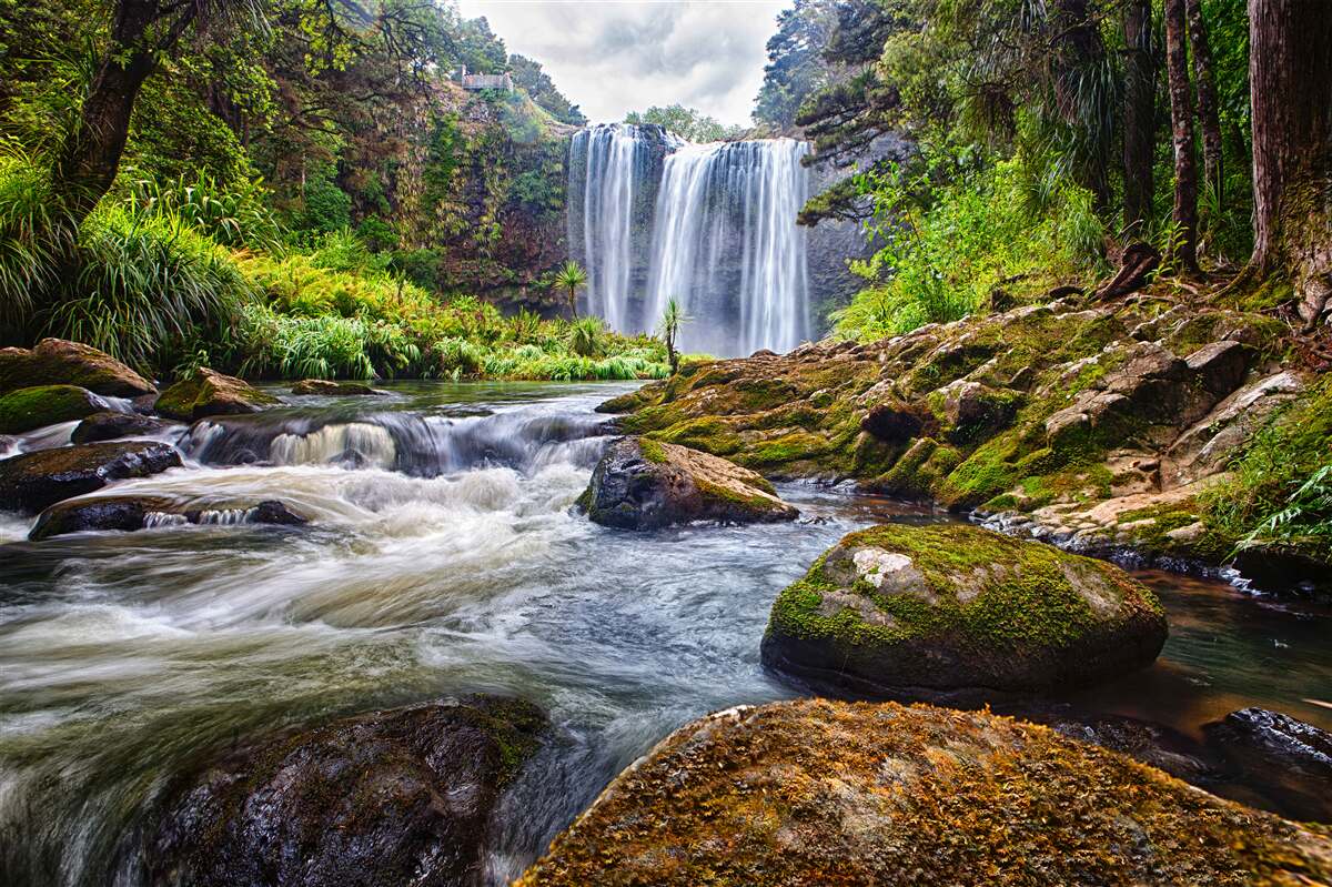 Fotobehang het luide geluid van een waterval die van de top van een berg valt