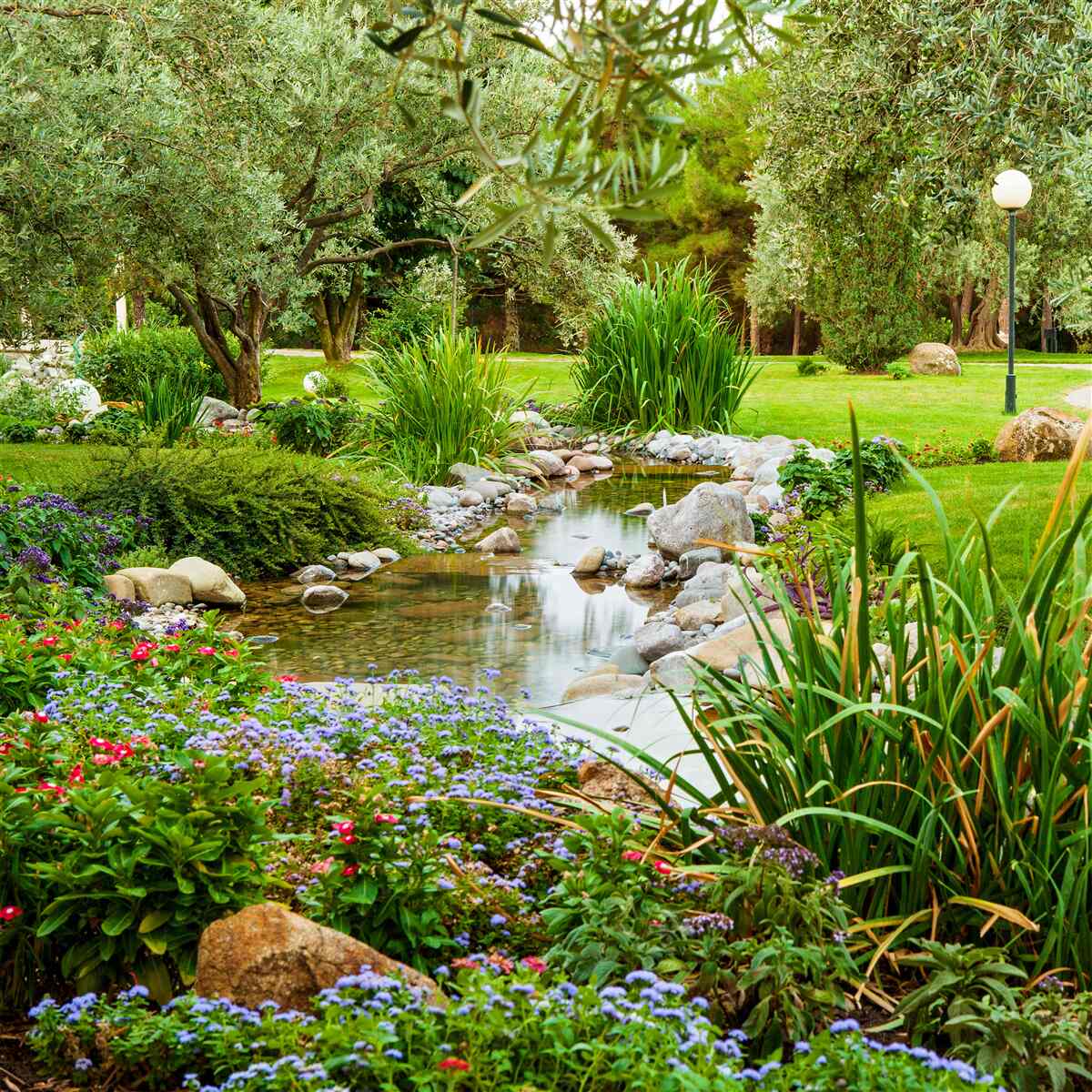Fotobehang een kalme beek op een smaragdgroene weide