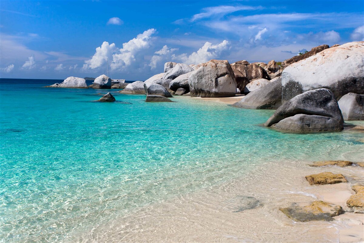 Fotobehang azuurblauw oceaanwater en een zandkust