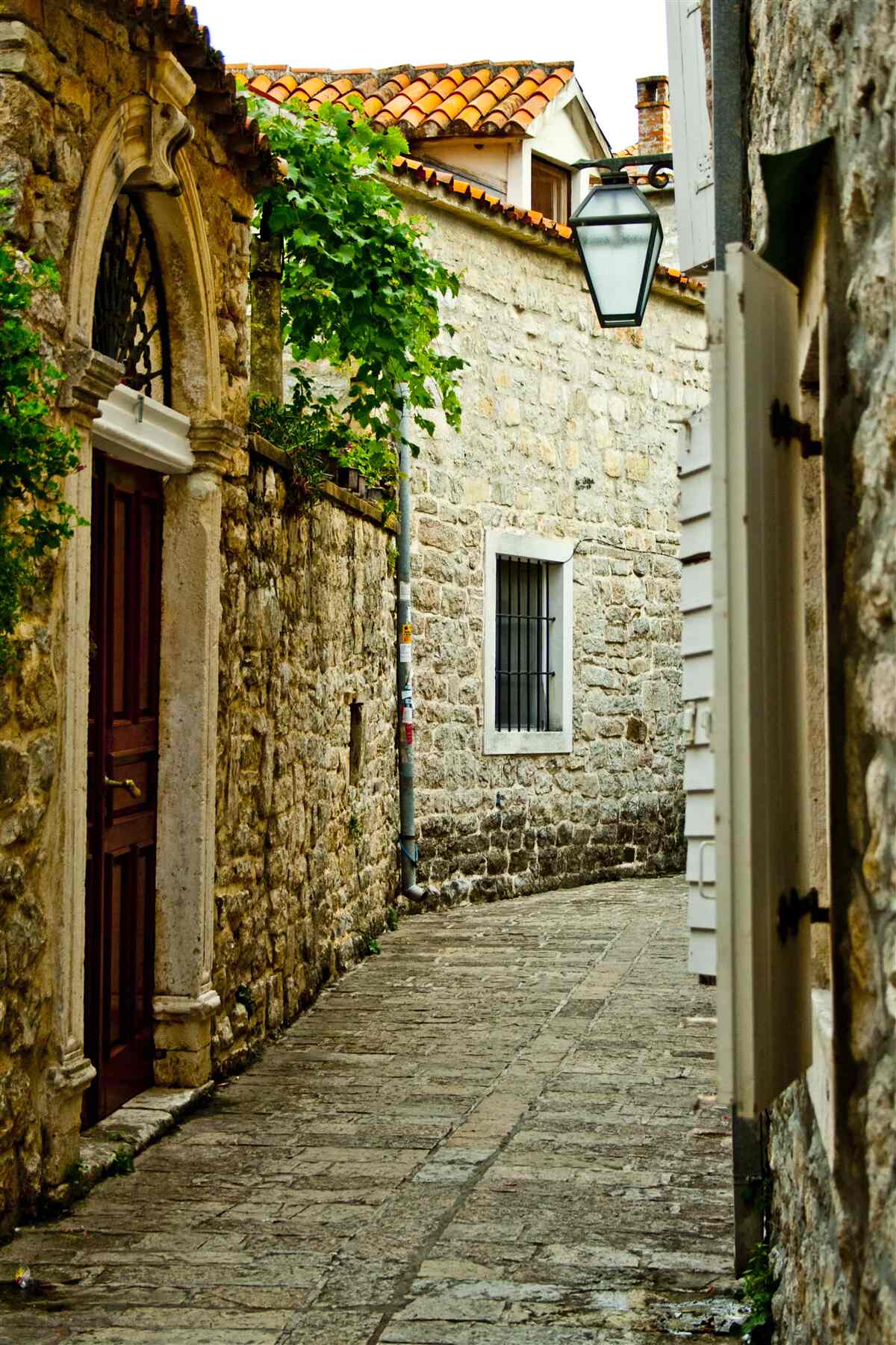 Fotobehang oude straat geplaveid met steen in de zomer