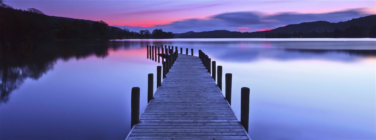 Fotobehang pier bij een meer in de bergen bij zonsopgang