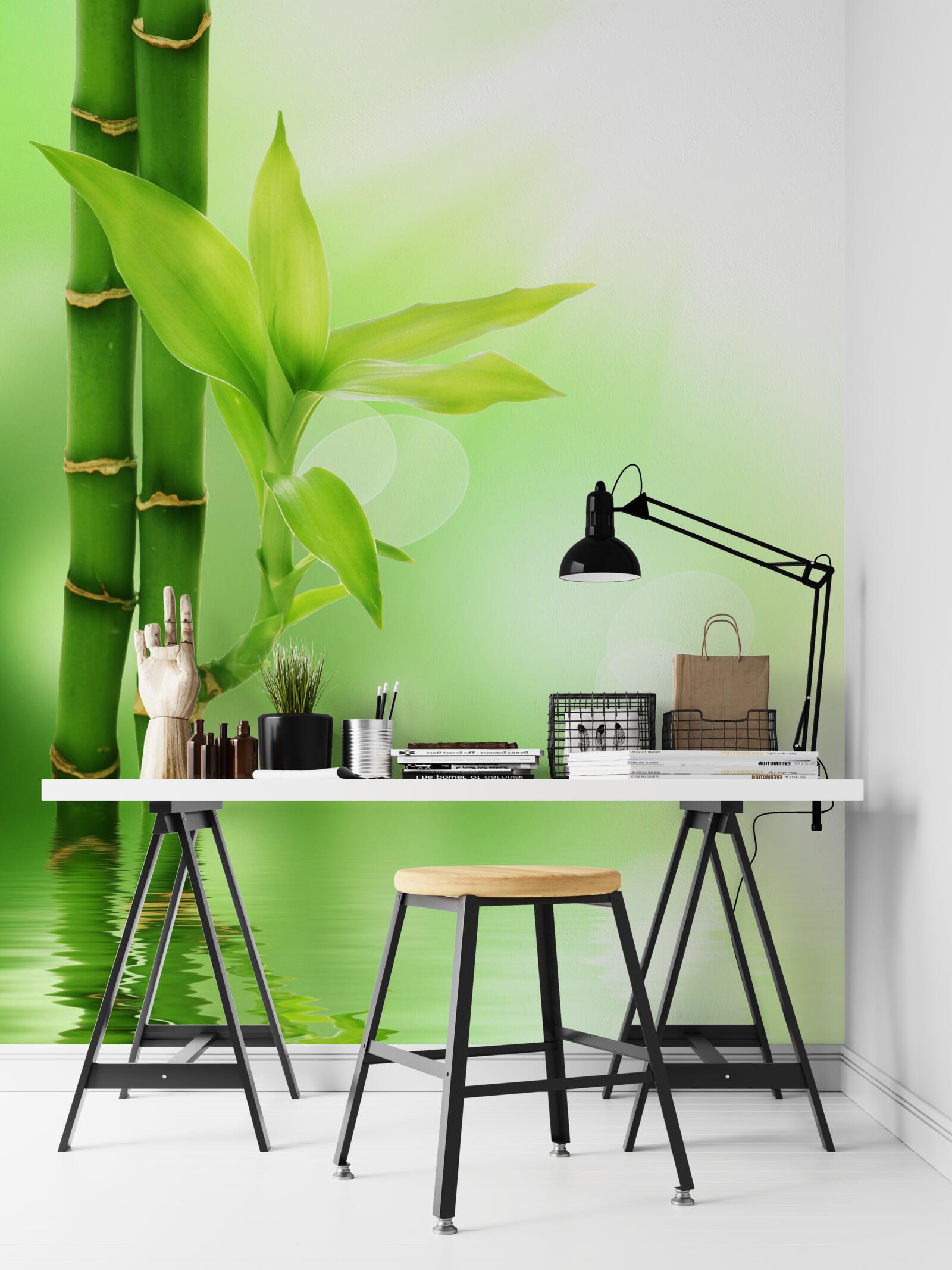 Fotobehang een bamboetak met bloemen op het wateroppervlak