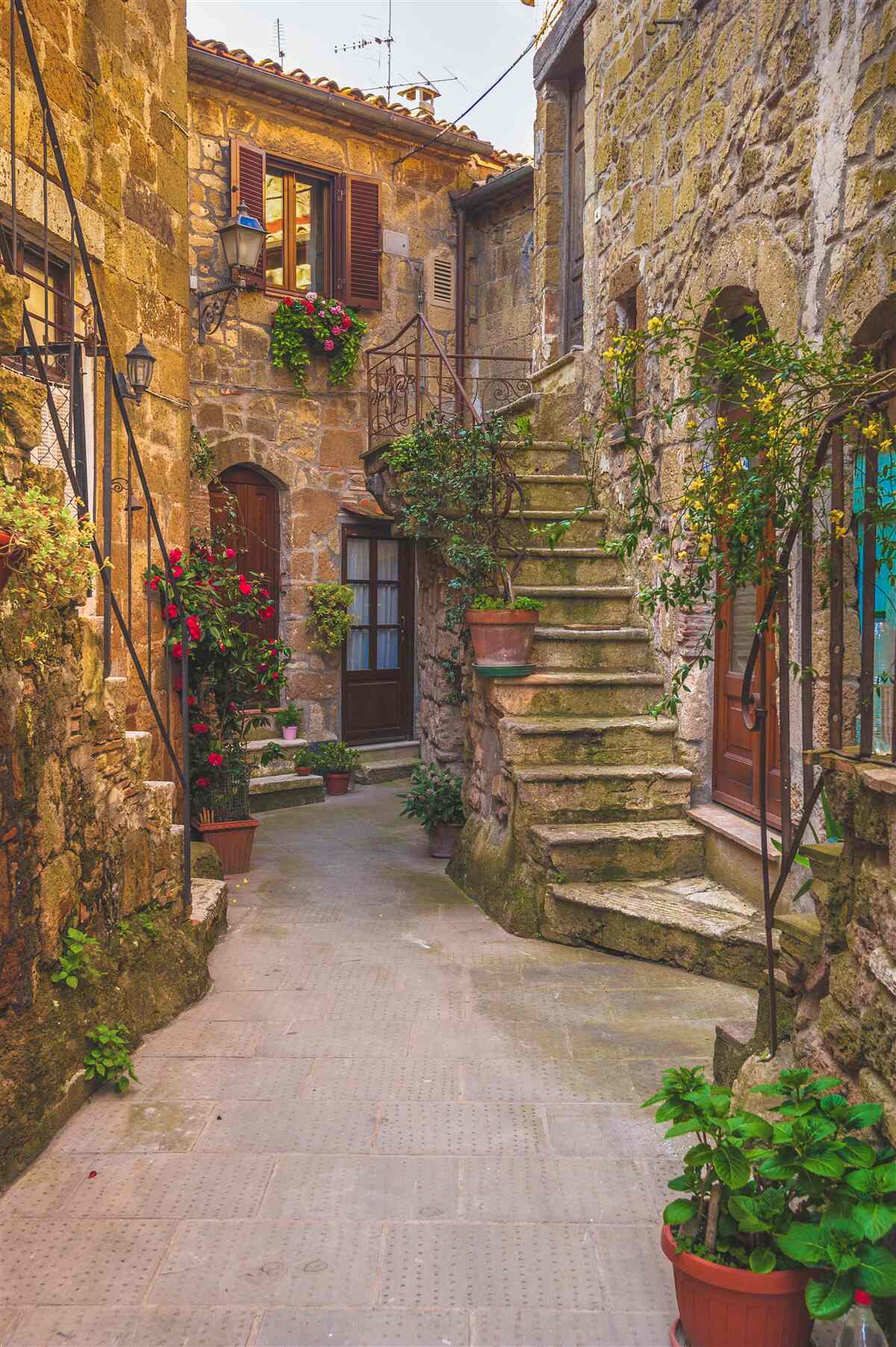 Fotobehang met bloemen versierde trap op de oude binnenplaats