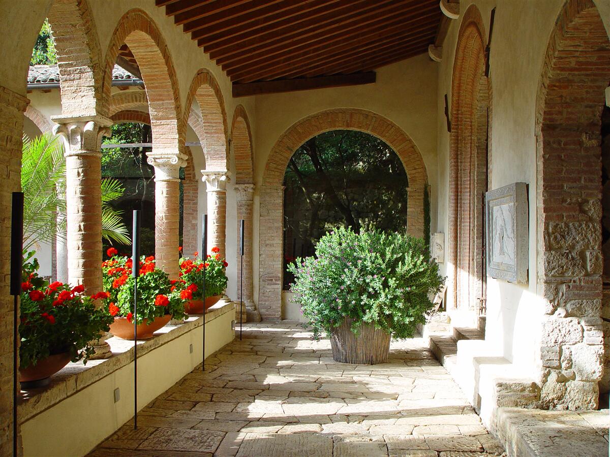 Fotobehang ronde stenen bogen en bloemen in potten
