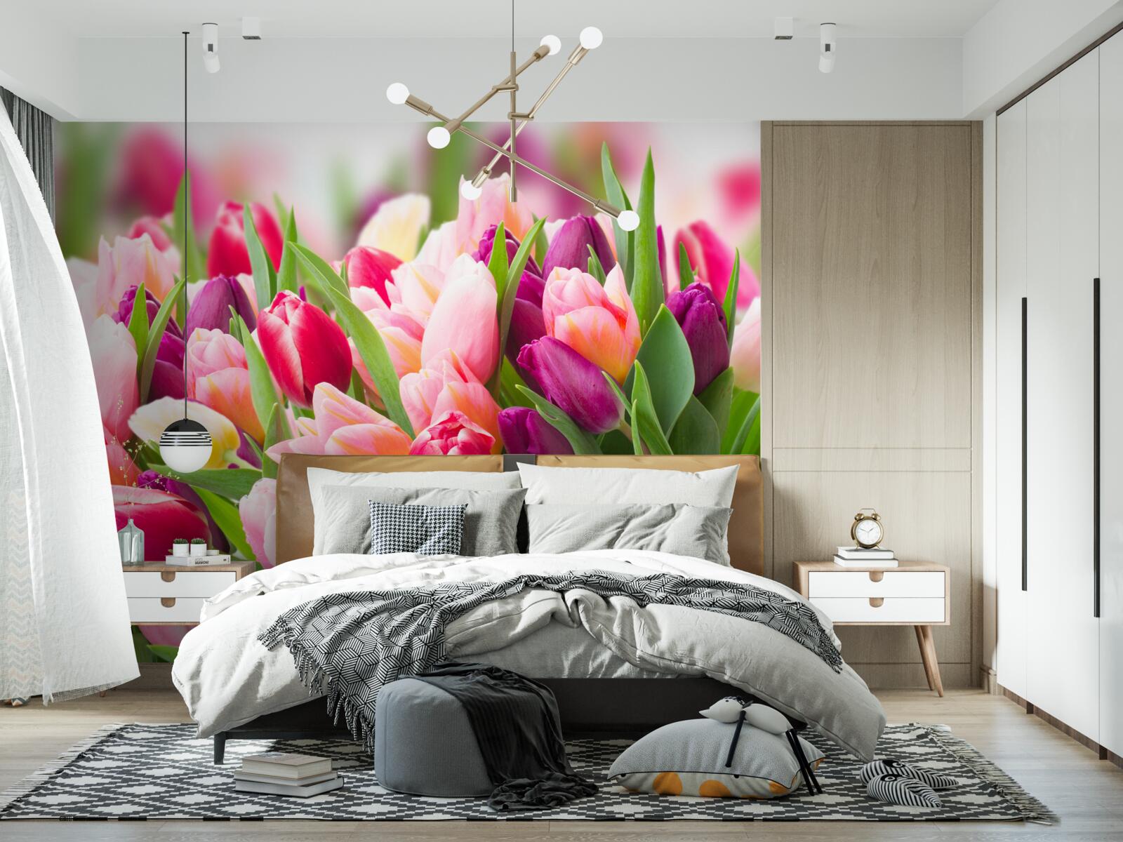Fotobehang heldere lentetulpen met groene bladeren