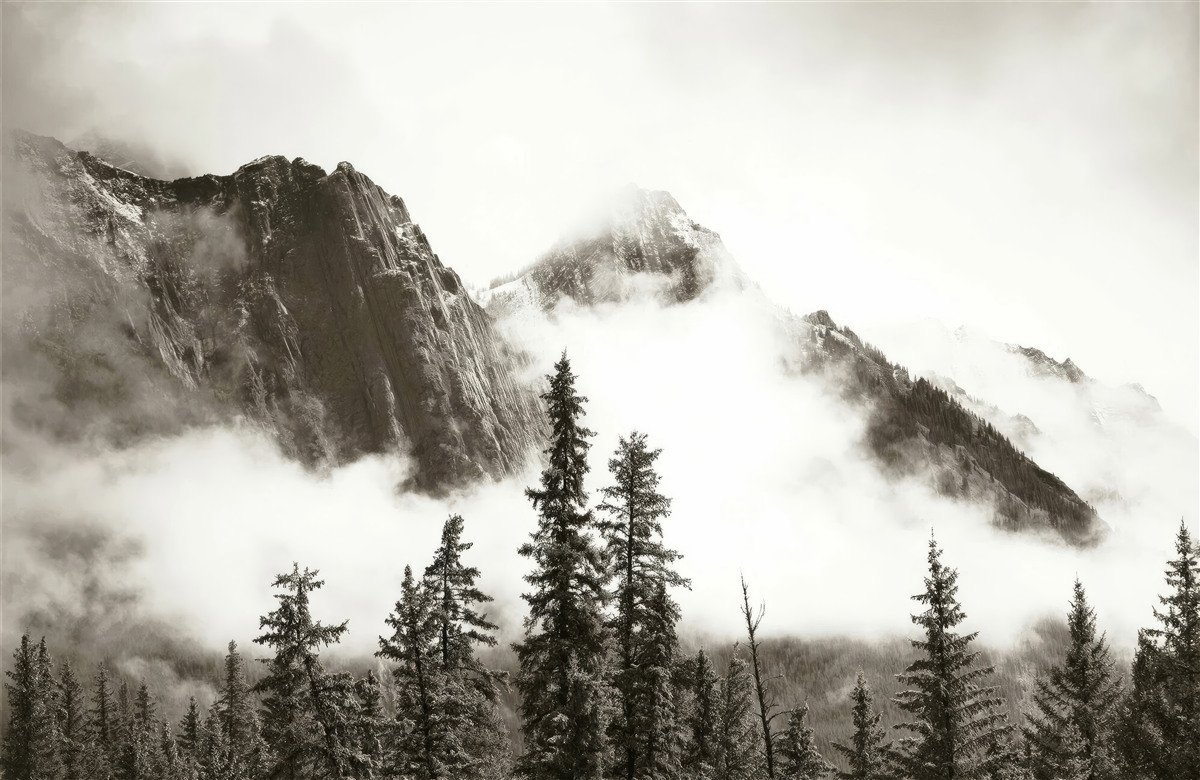 Fotobehang bergen in zwart en wit, gehuld in mist