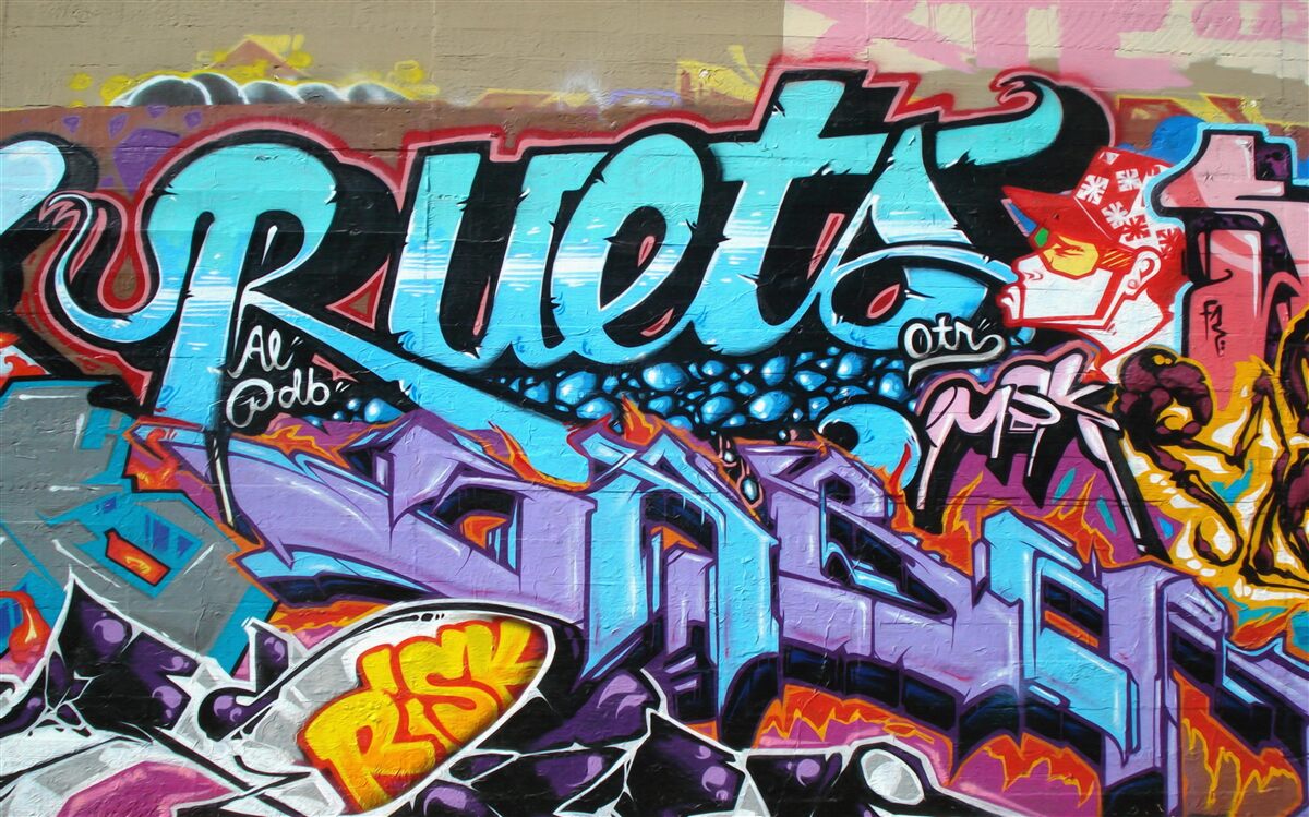 Fotobehang Muur versierd met felle graffiti